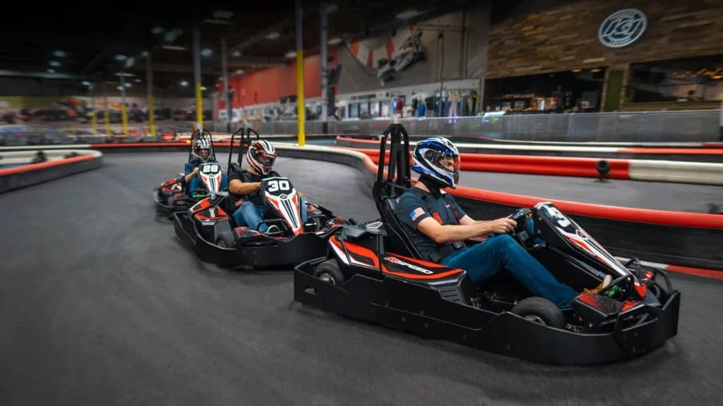 Three drivers running nose to tail on an indoor K1 Speed circuit